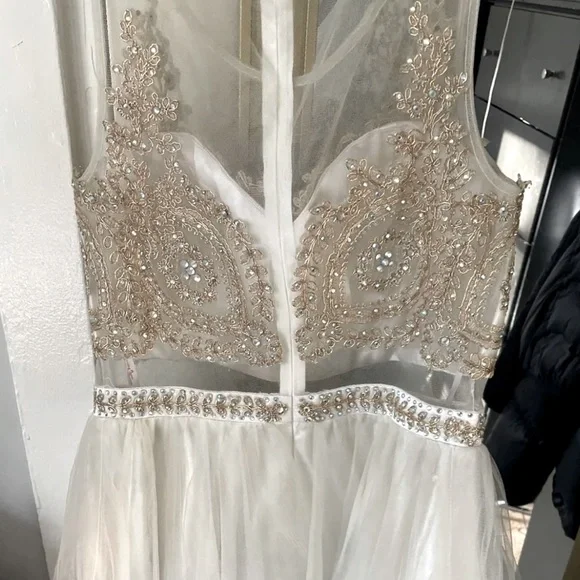 Beautiful beige dress with gold details on the top all around .